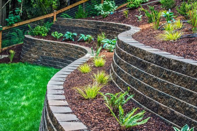 Curved retaining block walls defining garden terraces