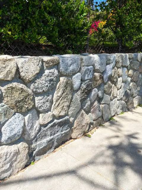 Natural stone wall beside a walkway